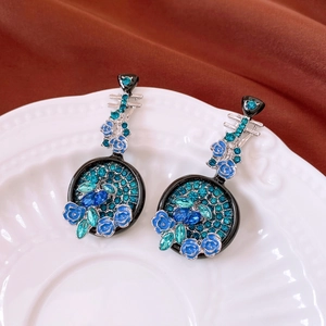 Detailed view of vintage pipa-shaped earrings with blue enamel roses and crystals