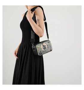 Side view of the Halloween witch print crossbody bag worn by a model to show product scale