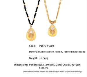 Detail of starburst teardrop pendants on black faceted bead and gold link chains