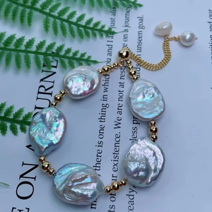 Dettaglio del bracciale con perle barocche, grani dorati e chiusura a cordoncino regolabile