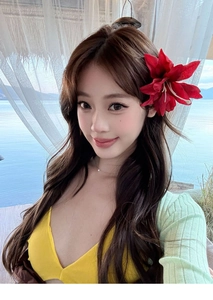 Detail showing a large red fabric flower hair clip worn for a summer beach vacation look