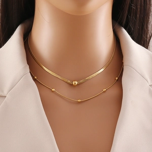 Zweilagige goldene Edelstahlhalskette mit Schlangenkette und rundem Anhänger am Modell