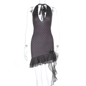 Détail de robe élégante à pois noirs avec décolleté en V profond et ourlet à volants