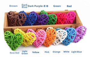 Thirteen colorful handcrafted rattan hearts displayed on a wooden tray for decoration