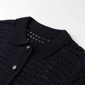 Detailed view of black open-knit polo sweater featuring collar texture and buttons