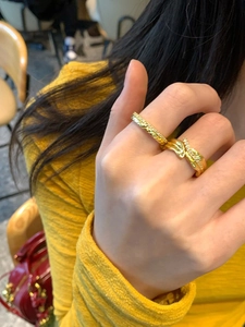 Detail of 18K gold plated zircon rings set featuring a twisted leafy design and textured band