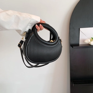 Classic black saddle bag with vertical striped texture and circular cutout handle