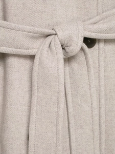 Dettaglio cappotto di lana color avena con cintura regolabile e bottone marrone scuro