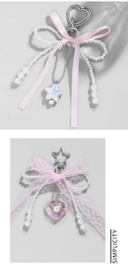 Detail of pink lace bow keychain with pearl tassel and heart-shaped metal clasp accessory