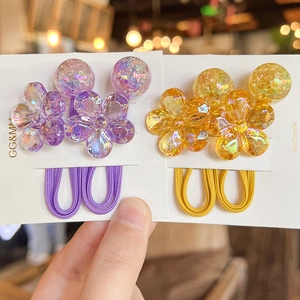 Detail of purple and yellow camellia flower hair ties with beads on display cards