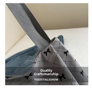 Close-up of quilted corduroy fabric with black bow embroidery on a large tote bag