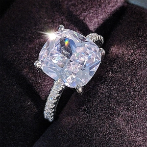 Macro shot of silver square cut engagement ring with pave set stones in a jewelry box