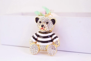 Macro shot of gold-plated striped bear keychain with sparkling rhinestones and enamel