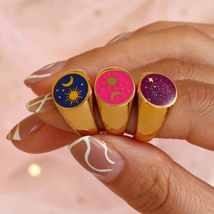Tre anelli a sigillo dorati con motivi celesti di sole e luna in smalto viola, blu e rosa