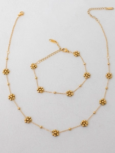 Detail of gold-plated stainless steel necklace and bracelet set with bead flower charms