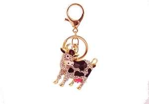 Detail of a sparkling cow keychain with clear crystals and golden lobster clasp