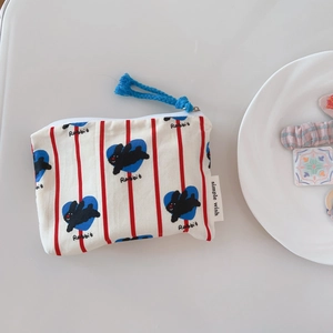 Close-up of canvas coin purse with red stripes, blue hearts, and rabbit pattern details