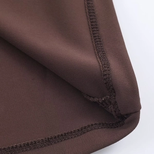 Detailansicht von schokobraunem Strickstoff mit verstärkter Overlock-Nahtverarbeitung