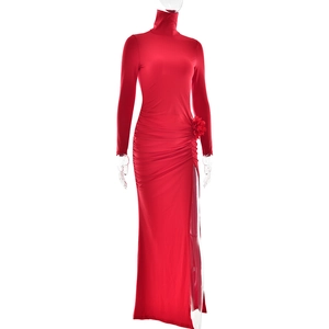 Close-up of red high-neck dress with pleated fabric, side slit and 3D floral detail
