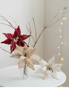 Gros plan de poinsettias en velours avec bords dorés en bordeaux, champagne et crème
