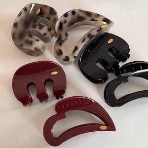 Top view of six assorted French style heart and semi-circle hair claws in multiple colors