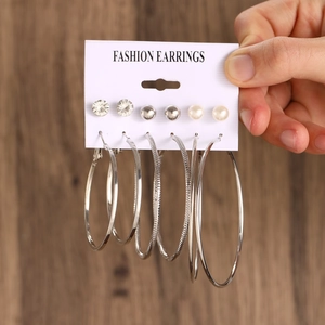 Close-up of 6 pairs silver earring set with pearls and hoops on a fashion display card