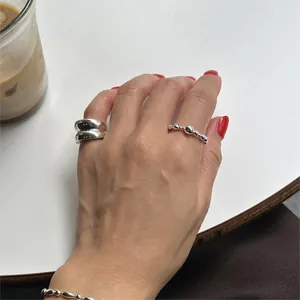 Detail of silver beaded stacking rings set on a white table with a coffee cup