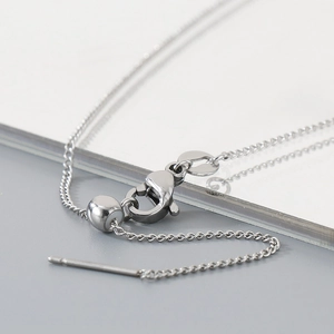 Macro shot of silver adjustable slider bead and lobster clasp on fine necklace chain