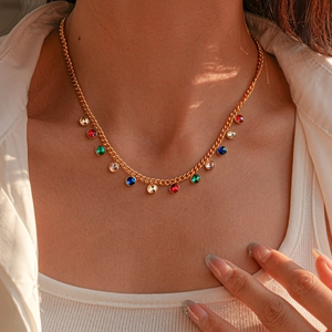 Detail of gold-plated sweater chain necklace featuring colorful round gemstones on model