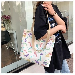 Detailed close-up of a large canvas tote bag with colorful abstract geometric prints