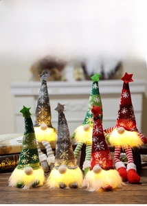 Detail of lighted Christmas gnomes with knitted snowflake hats and warm LED glow