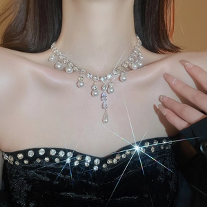 Close-up of elegant silver necklace with pearls and sparkling rhinestones on neck