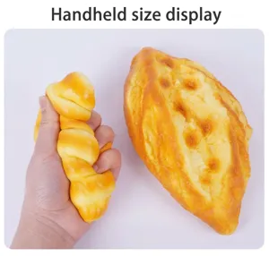 Detalle de una mano apretando un juguete de croissant realista de espuma de PU