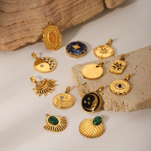 Golden celestial charms set with sun moon and star motifs on natural stone background