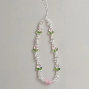Macro detail of tulip beaded phone strap with clear faceted beads and pink floral charms