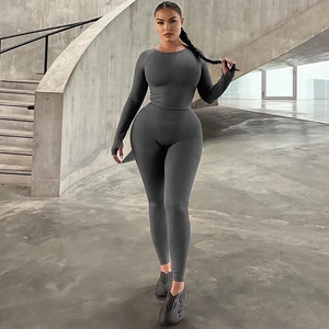 Detail of high-waist yoga leggings and long sleeve sports top in dark grey stretch fabric