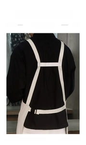 H-shaped back strap detail of white waterproof canvas apron with adjustable buckle