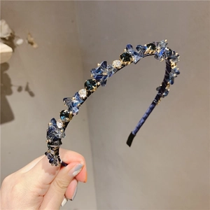 Macro detail of luxury blue crystal headband with intricate faceted stones and shimmer
