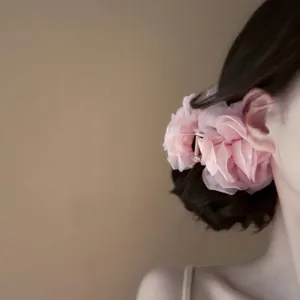 Vista dettagliata della molletta per capelli a rosa in tessuto rosa indossata sui capelli