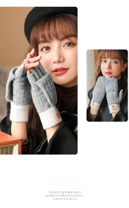 Detail view of gray knitted flip-top gloves with ribbed cuffs and leather badge ornament