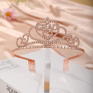 Rose gold graduation crown with GRAD lettering and rhinestones on silk background