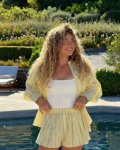 Detail shot of yellow and blue striped leisure shirt and shorts set by the swimming pool