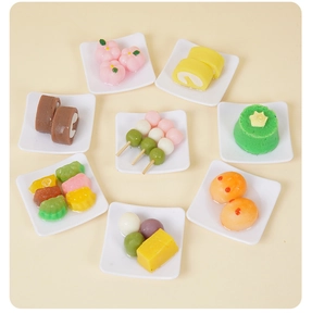 Dettaglio di vari portachiavi a forma di dessert in miniatura con vassoi color pastello