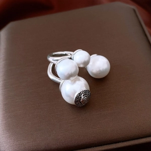Close-up of vintage silver pearl ring with Medusa head and Greek key pattern engraving
