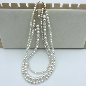 Close-up of triple-layered white pearl necklace with adjustable 14k gold-filled clasp