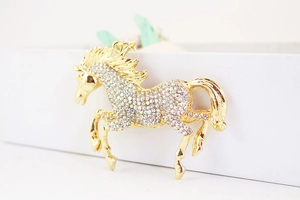Close-up of golden horse keychain featuring sparkling rhinestones and detailed metal craftsmanship