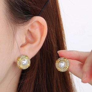 Macro view of gold 18k oval stainless steel stud earrings with pearls and rhinestones