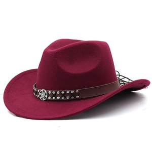Detail of burgundy felt cowboy hat with leather belt, silver rivets and metal emblem