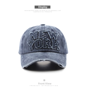 Close-up of distressed denim baseball cap with NEW YORK applique and frayed visor details
