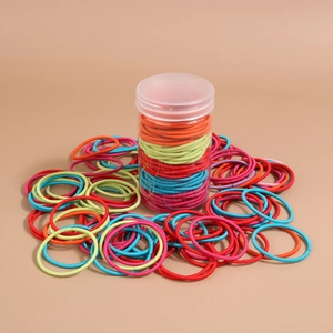 Primo piano di elastici per capelli colorati in un barattolo di plastica trasparente